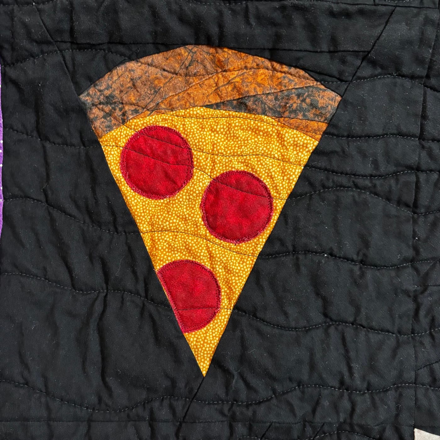 Quilted pepperoni pizza slice block on black fabric
